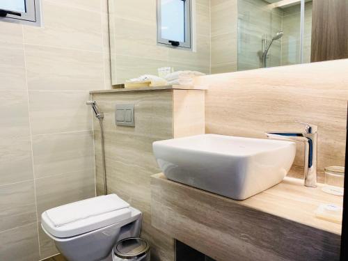 a bathroom with a white sink and a toilet at Aurora Western Village in Ho Chi Minh City