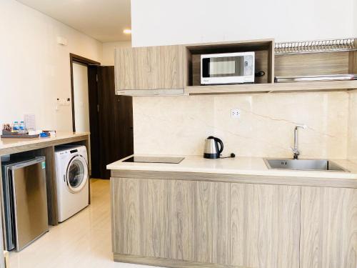 a kitchen with a sink and a microwave at Aurora Western Village in Ho Chi Minh City