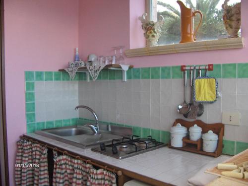 a kitchen with a sink and a stove top oven at Casa Vacanza sul Mare in Cefalù