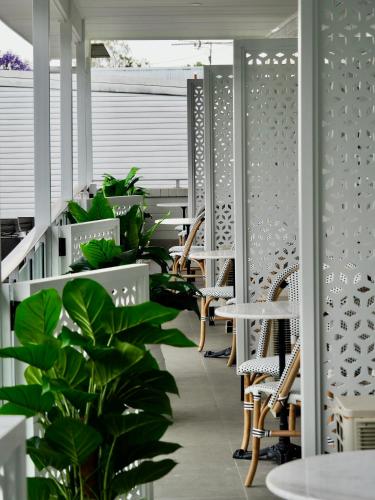a room with plants and tables and chairs at The Esplanade Motel in Warners Bay
