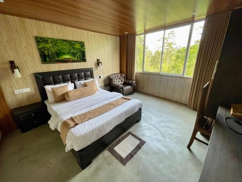 a bedroom with a large bed and a chair at Daddy's Guest Adam's Peak in Nallathanniya