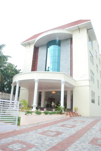 a large white building with a staircase in front of it at Hotel Vpn Residency in Velānganni