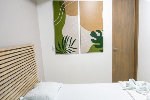 a bedroom with two pictures on the wall at M1145 Aparta Loft in Pereira