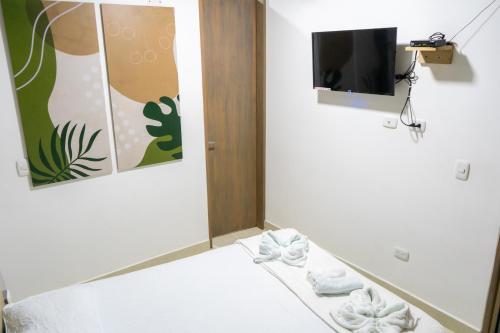 a room with a tv and some white towels at M1145 Aparta Loft in Pereira