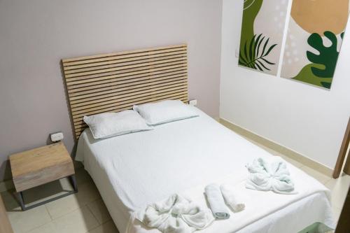 a small bedroom with a white bed with towels on it at M1145 Aparta Loft in Pereira