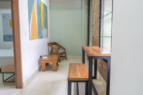 two tables and benches in a room with a window at M1145 Aparta Loft in Pereira