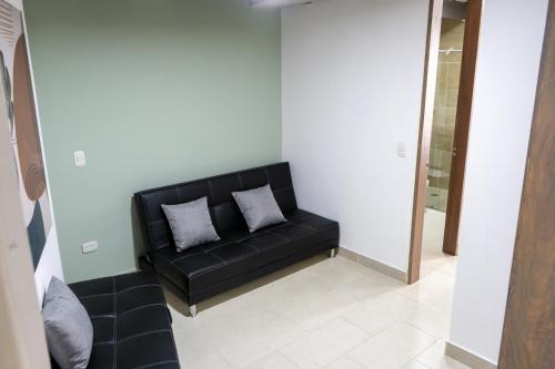 a black couch with two pillows in a room at M1145 Aparta Loft in Pereira