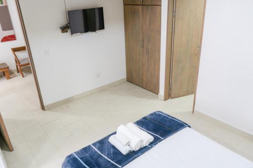a room with a towel on the floor and a tv at M1145 Aparta Loft in Pereira