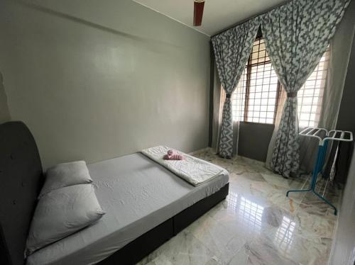 a bedroom with a bed and two windows at LEPAK-LEPAK HOMESTAY @ INDERA MAHKOTA in Kuantan