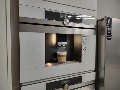 una taza de café está sentada dentro de un horno en Modern 3 bedroom apartment near Useldange castle, en Useldange