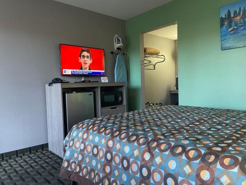 a bedroom with a bed and a flat screen tv at Travel Inn in South Lake Tahoe