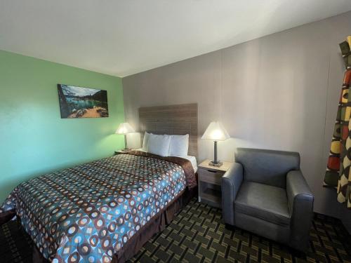 a hotel room with a bed and a chair at Travel Inn in South Lake Tahoe