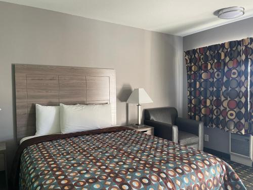 a hotel room with a bed and a chair at Travel Inn in South Lake Tahoe