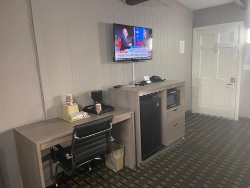 a room with a desk with a television on the wall at Travel Inn in South Lake Tahoe