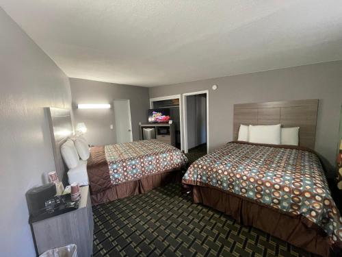 a hotel room with two beds and a television at Travel Inn in South Lake Tahoe