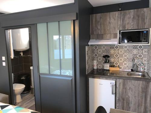 une cuisine avec une porte menant à une salle de bains. dans l'établissement Le Petit Chaleureux - Centre ville - Wifi - stationnement (idéal couples, étudiants, business), à Niort