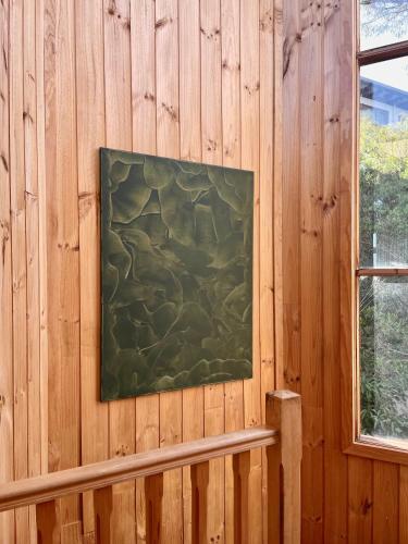 a painting hanging on a wooden wall with a bench at Kinoie Mornington - OCEANVIEW in Mount Martha