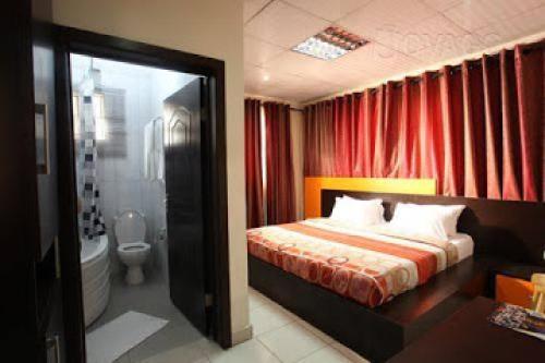 a bedroom with a bed and a red curtain at Room in Lodge - Prince Of Anthony 1960 Hotel-apartment in Lagos