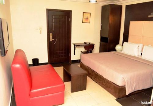 a hotel room with a bed and a red chair at Room in Lodge - Prince Of Anthony 1960 Hotel-apartment in Lagos