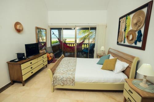 um quarto com uma cama, uma televisão e uma varanda em GUAJIRA CASA DEL MAR em Ríohacha