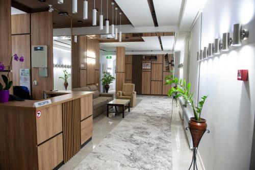 an office lobby with a reception desk and chairs at Lotus Hotel Chisinau in Chişinău