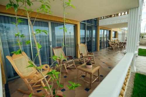 a balcony with rocking chairs and a table at GUAJIRA CASA DEL MAR in Ríohacha