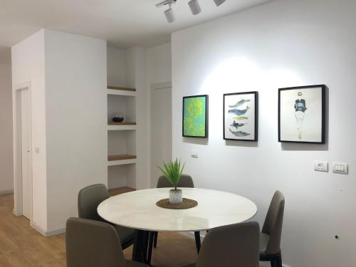 a white dining room with a table and chairs at SUCASA RA’ANANA in Ra‘ananna