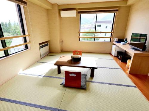 an empty room with a table and a desk at Apprising hotels GranJam Tsugaike in Otari