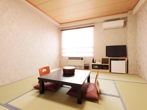 a room with a table and chairs in it at Apprising hotels GranJam Tsugaike in Otari
