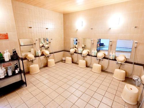 a bathroom with a bunch of urinals in a room at Apprising hotels GranJam Tsugaike in Otari