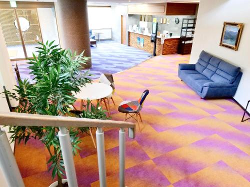 a lobby with a couch and a table and chairs at Apprising hotels GranJam Tsugaike in Otari