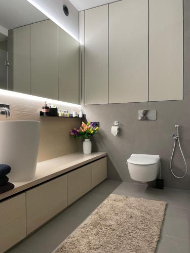 a bathroom with a toilet and a sink and cabinets at Arcadia in Odesa