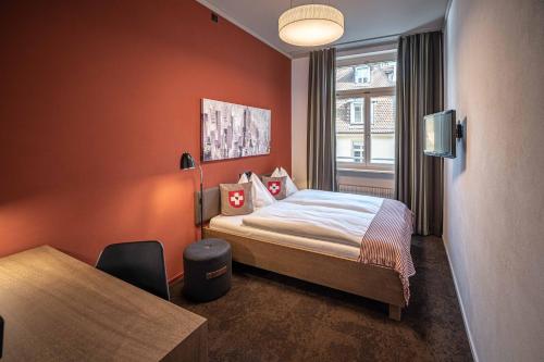 ein Hotelzimmer mit einem Bett und einem Fenster in der Unterkunft Hotel Bären am Bundesplatz in Bern