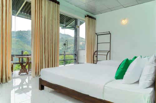 a bedroom with a bed and a large window at Cool Mount Resort in Ella