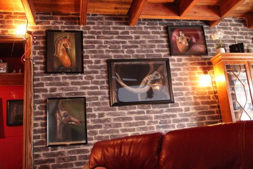 a brick wall with pictures of horses on it at Maison de charme, d'artiste, décoration brocante in Aigrefeuille-dʼAunis