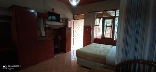 a bedroom with a bed and a window at Bungalow kampoengstrawberry ciwidey in Ciwidey