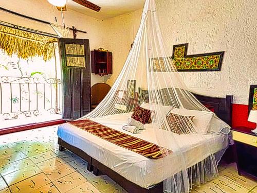 een slaapkamer met een bed met een net erop bij Beachfront Hacienda del Cuyo Groundfloor in El Cuyo