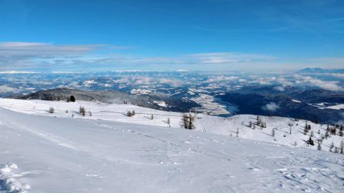 a snow covered mountain with a view of a city at GOOD Times Gerlitzen in Deutschberg