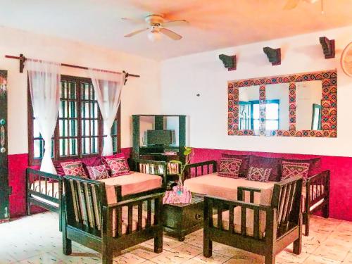 a room with two beds and a couch and a mirror at Beachfront 3 Bedroom 2 Terraces, Hacienda del Cuyo in El Cuyo