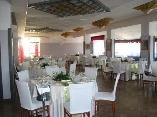 a room with white tables and white chairs and tablesearcher at Hotel Parco in Castellammare di Stabia