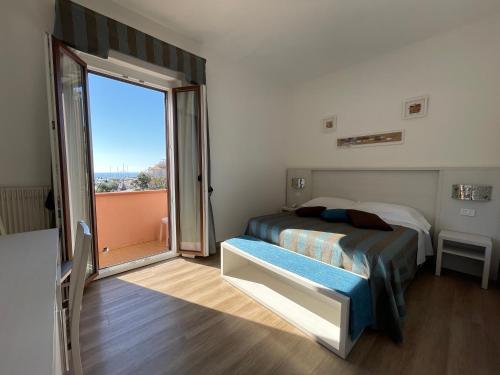 a bedroom with a bed and a large window at Hotel Lucerna in Castiglione della Pescaia