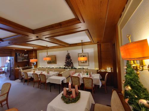 a dining room with tables and chairs and christmas trees at Hotel Adler in Lichtenstein/ Baden Wurttemberg