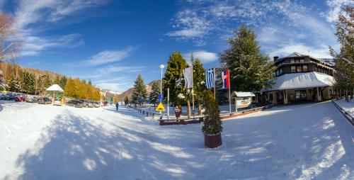 a snow covered street in front of a building at Guesthouse Junior in Kopaonik