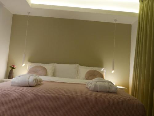 a bedroom with a large bed with two pillows on it at Mikiway סוויטה פנורמית בגלבוע in Bet HaShitta