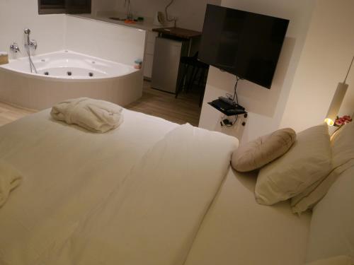 a bedroom with a bed with a tub and a television at Mikiway סוויטה פנורמית בגלבוע in Bet HaShitta