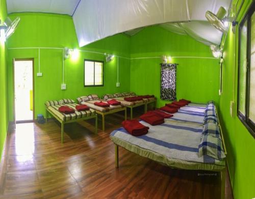Habitación con paredes verdes y camas. en Dandeli Eco VanaVasa by StayApart, en Dandeli