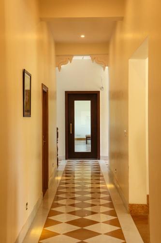 an empty hallway with a door and a checkered floor at Vasant Vilas in Udaipur