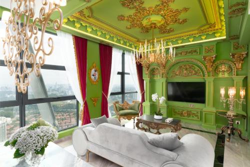 a living room with green walls and a chandelier at arte by Thomas Chan in Kuala Lumpur