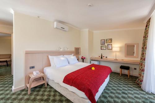 Habitación de hotel con cama grande con manta roja en Sagalassos Lodge & Spa Hotel, en Ağlasun