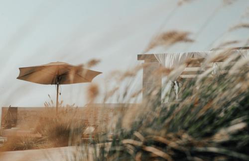 een parasol die op een strand staat bij TheLuxuryVillas in Preveza